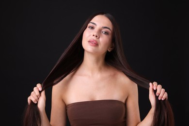 Photo of Woman with beautiful smooth hair after lamination procedure on black background