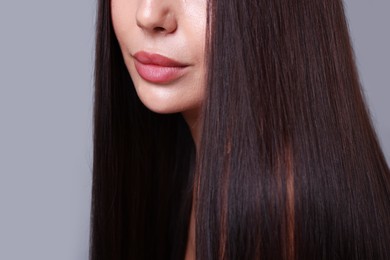 Photo of Woman with beautiful smooth hair after lamination procedure on light grey background, closeup