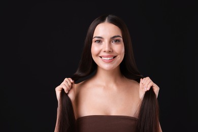 Photo of Woman with beautiful smooth hair after lamination procedure on black background
