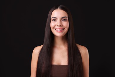 Photo of Woman with beautiful smooth hair after lamination procedure on black background