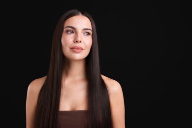 Photo of Woman with beautiful smooth hair after lamination procedure on black background, space for text