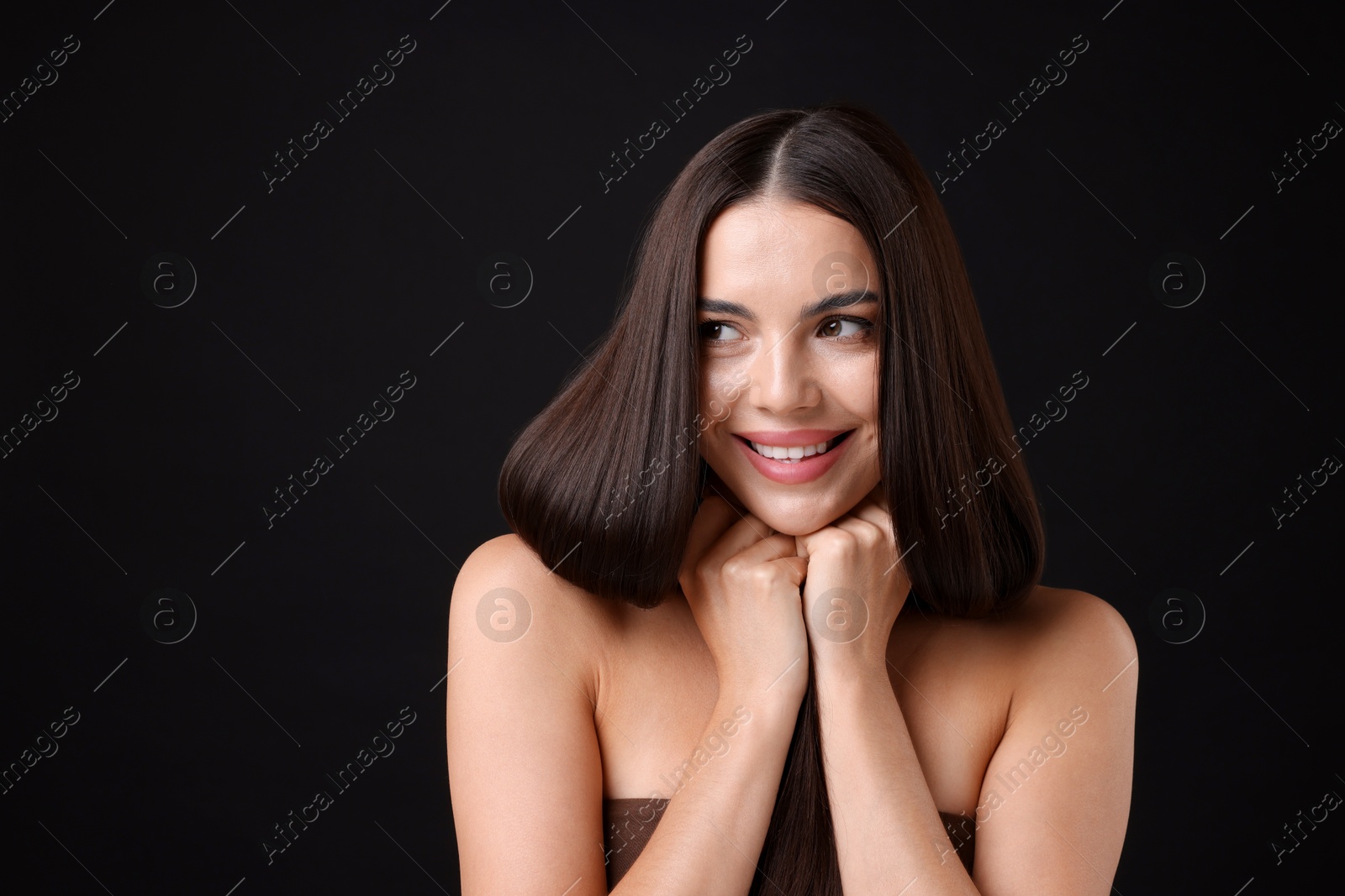 Photo of Woman with beautiful smooth hair after lamination procedure on black background