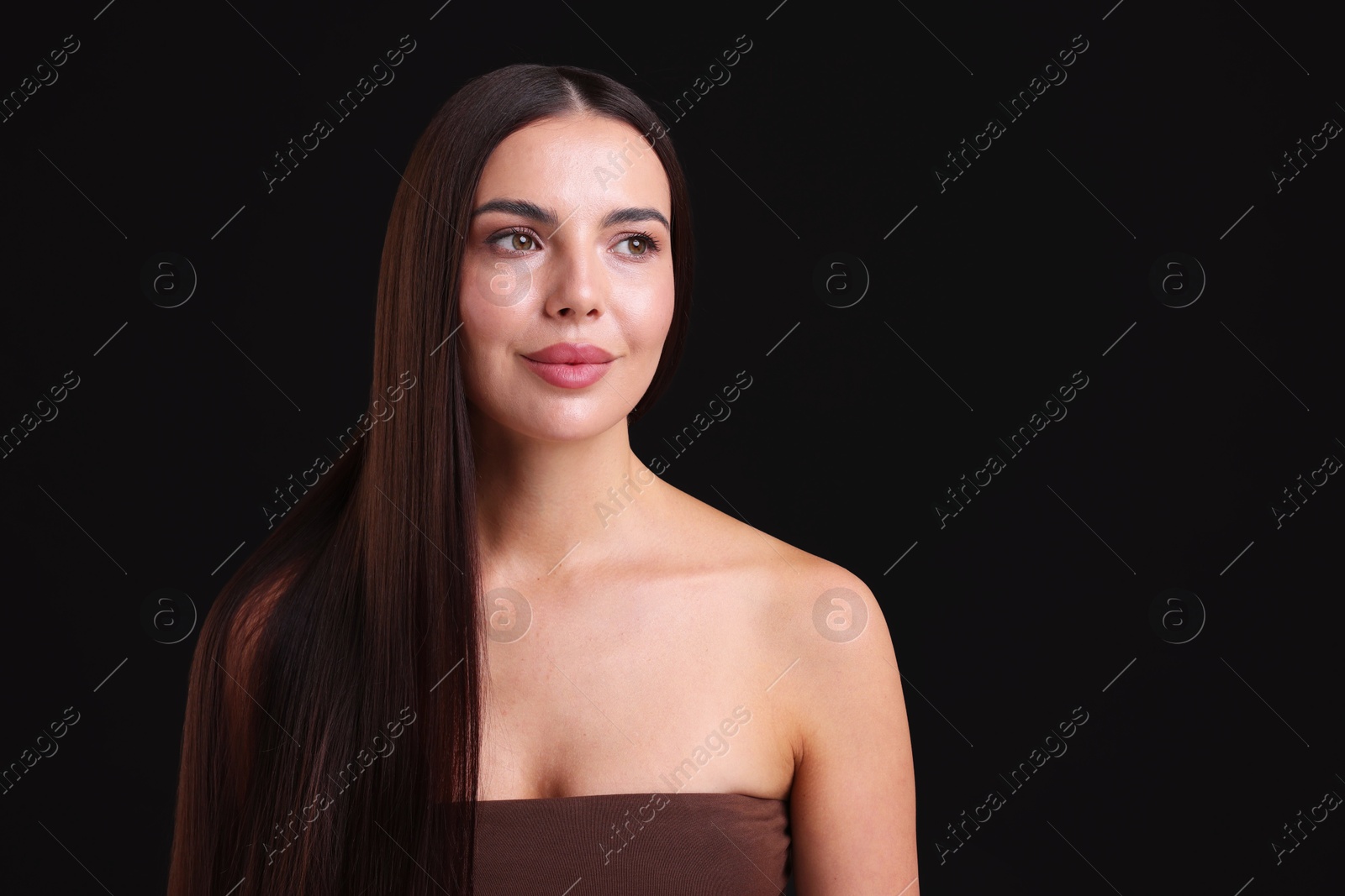 Photo of Woman with beautiful smooth hair after lamination procedure on black background