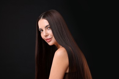 Photo of Woman with beautiful smooth hair after lamination procedure on black background