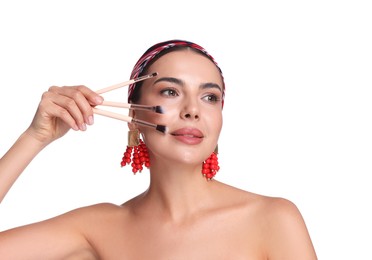 Photo of Beautiful woman with makeup brushes on white background