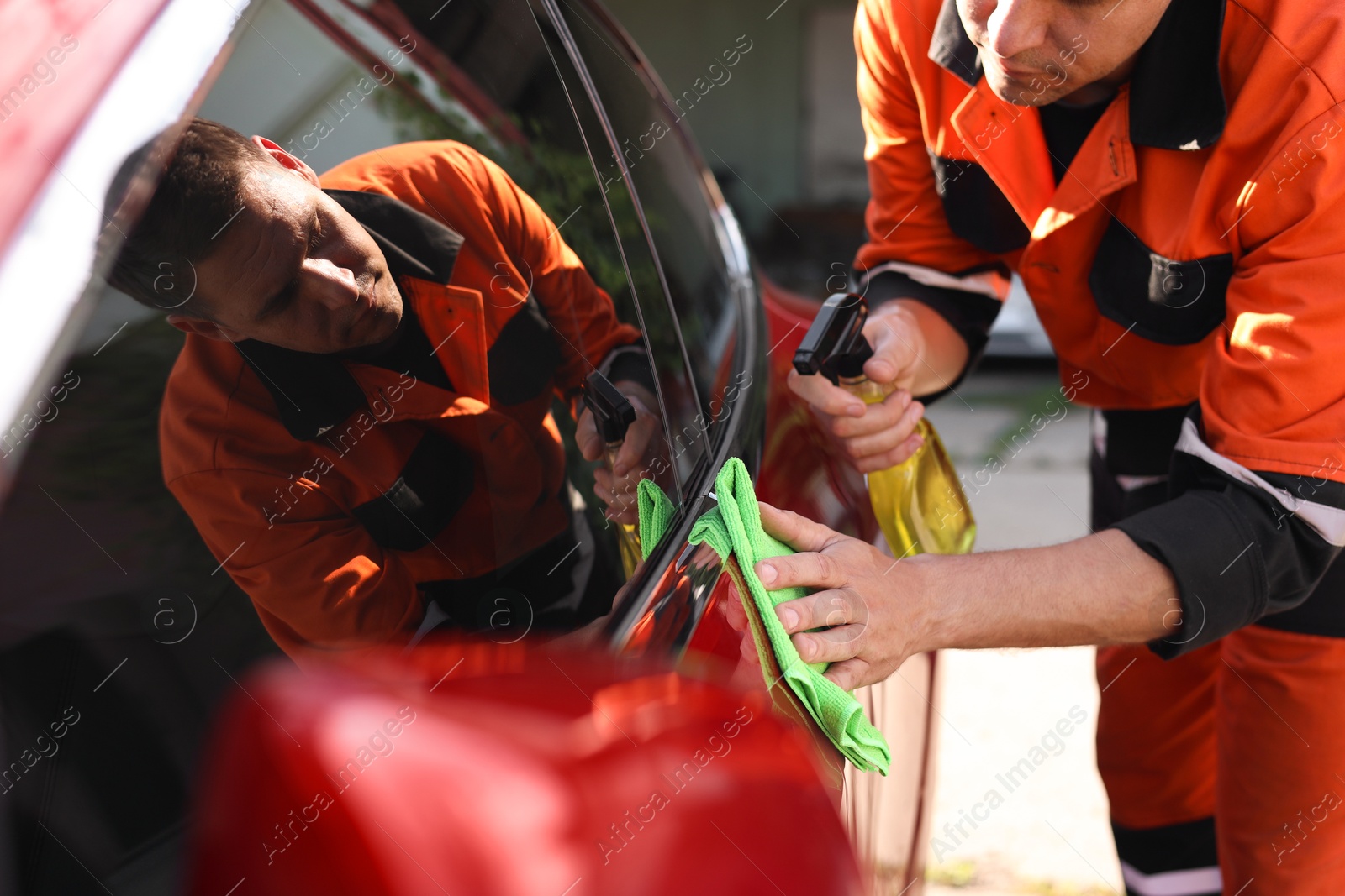 Man wiping car with green microfiber rag outdoors, closeup Photo of Man wiping car with green microfiber rag outdoors, closeup