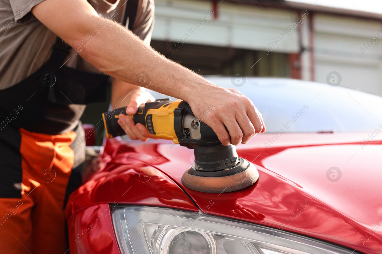 Man polishing car hood with orbital polisher outdoors, closeup Photo of Man polishing car hood with orbital polisher outdoors, closeup