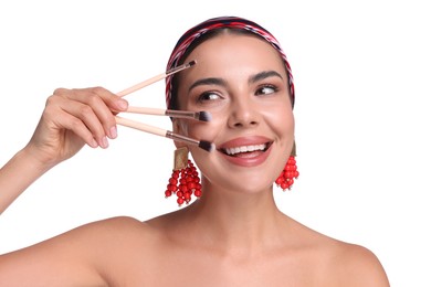 Photo of Beautiful woman with makeup brushes on white background