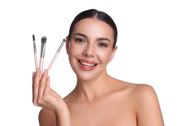 Photo of Beautiful woman with makeup brushes on white background