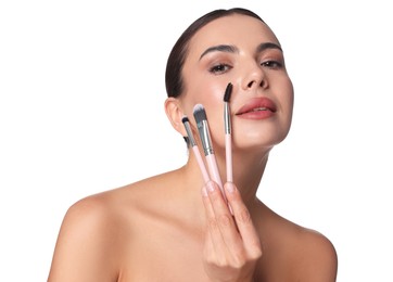 Photo of Beautiful woman with makeup brushes on white background