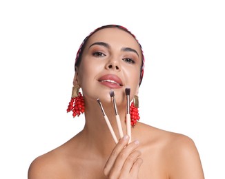 Photo of Beautiful woman with makeup brushes on white background