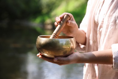 Photo of Woman with singing bowl in nature, closeup