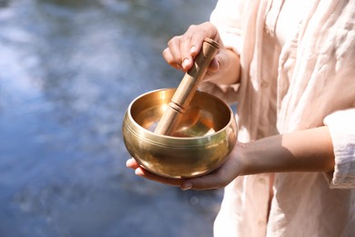 Photo of Woman with singing bowl in nature, closeup