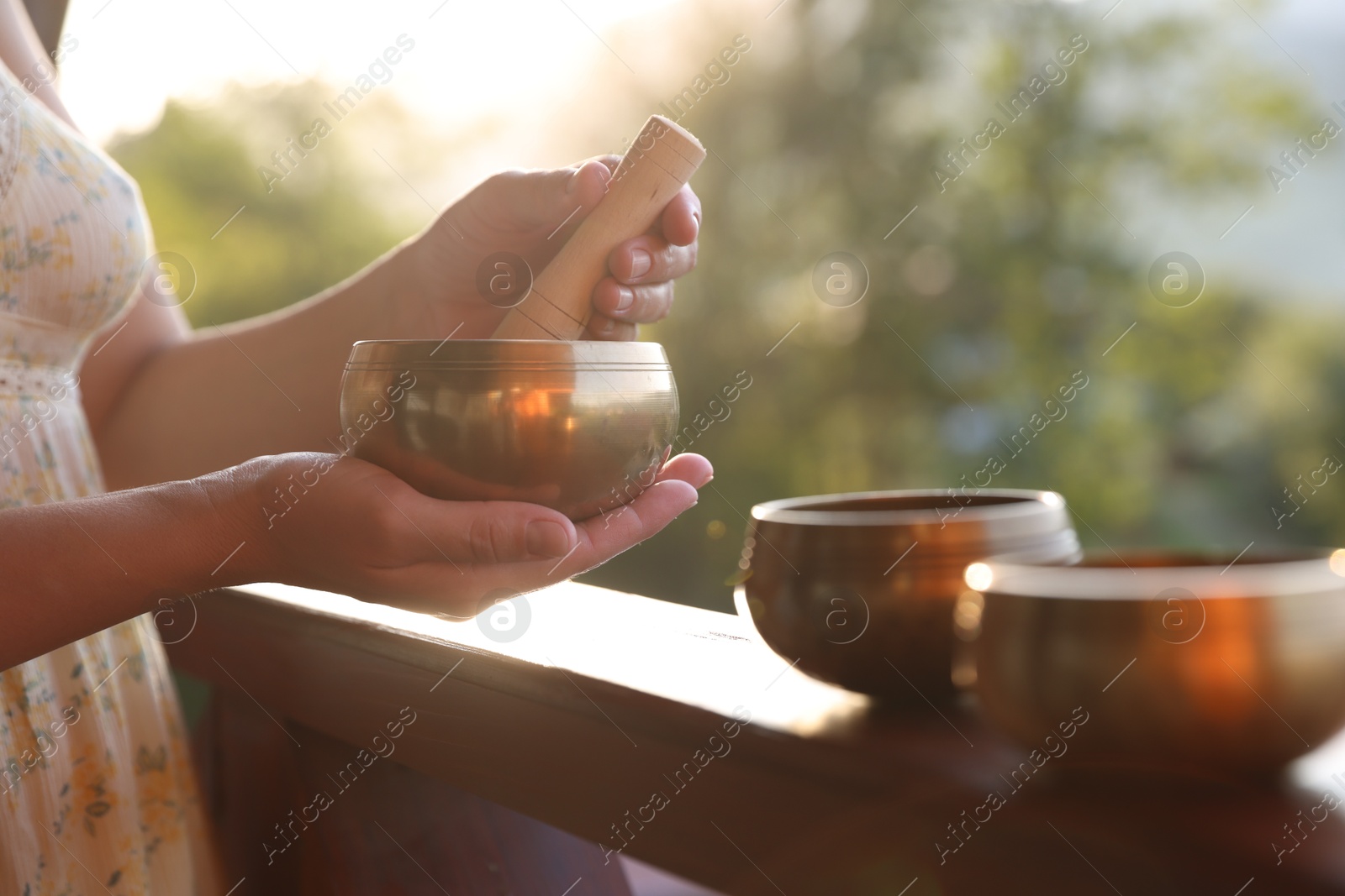 Photo of Woman with singing bowls outdoors on sunny day, closeup