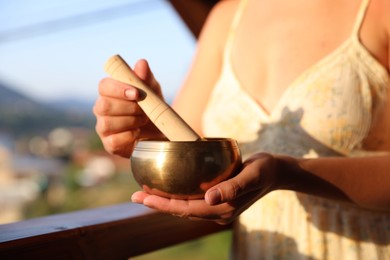 Photo of Woman with singing bowl outdoors on sunny day, closeup