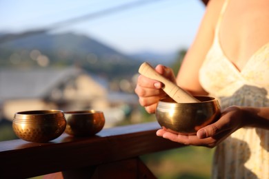 Photo of Woman with singing bowls outdoors on sunny day, closeup