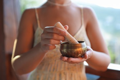 Photo of Woman with singing bowl outdoors, closeup view