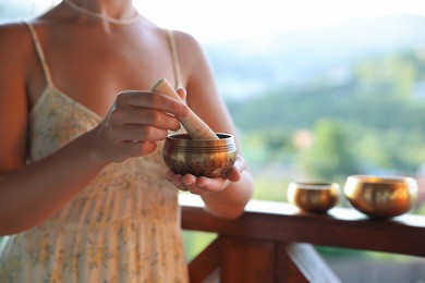 Photo of Woman with singing bowl outdoors, closeup view