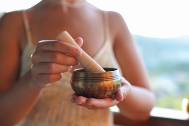 Photo of Woman with singing bowl outdoors, closeup view