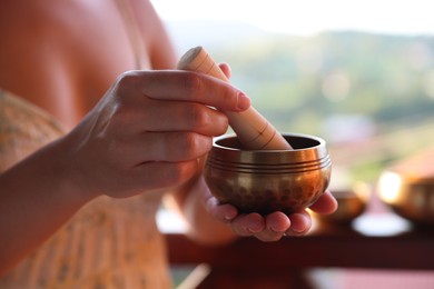 Photo of Woman with singing bowl outdoors, closeup view