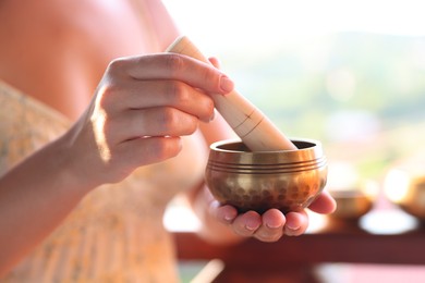 Photo of Woman with singing bowl outdoors, closeup view