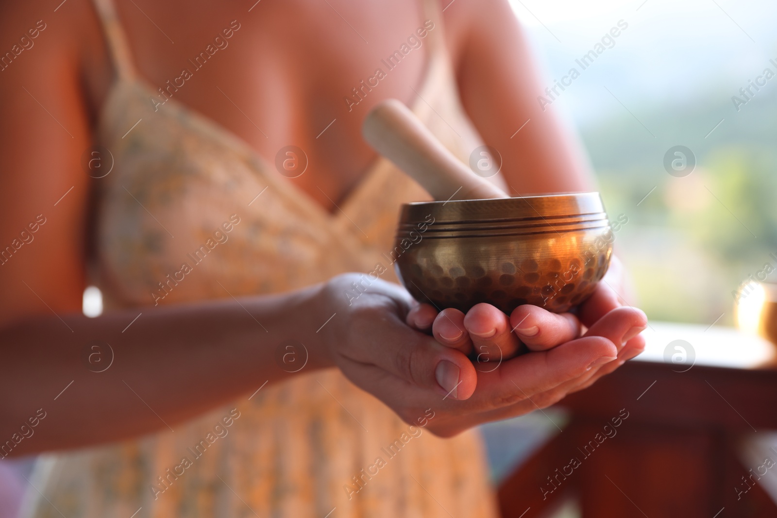 Photo of Woman with singing bowl outdoors, closeup view