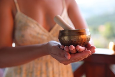 Photo of Woman with singing bowl outdoors, closeup view