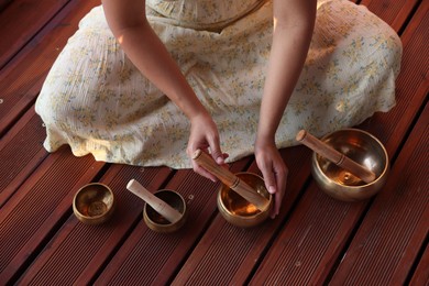 Photo of Woman with singing bowls on floor, above view