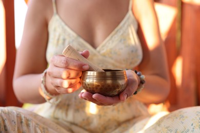 Photo of Woman with singing bowl outdoors on sunny day, closeup
