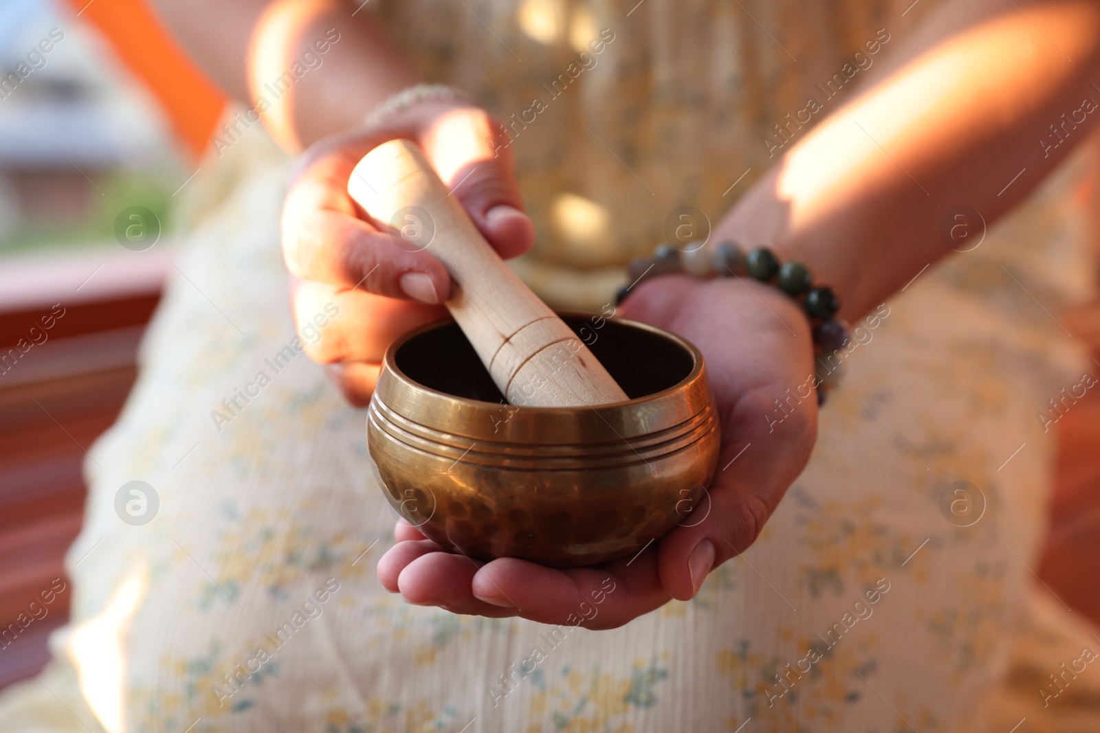 Photo of Woman with singing bowl outdoors, closeup view