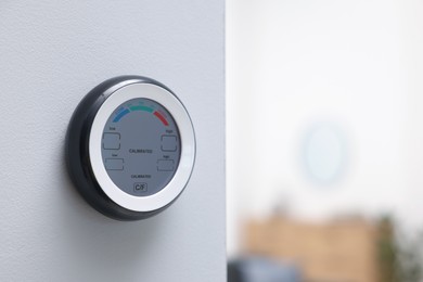 Photo of One hygrometer on white wall indoors, space for text. Smart home system