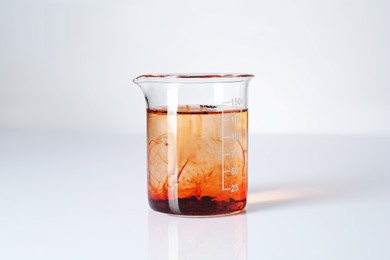 Photo of Glass beaker with dirty water on white background