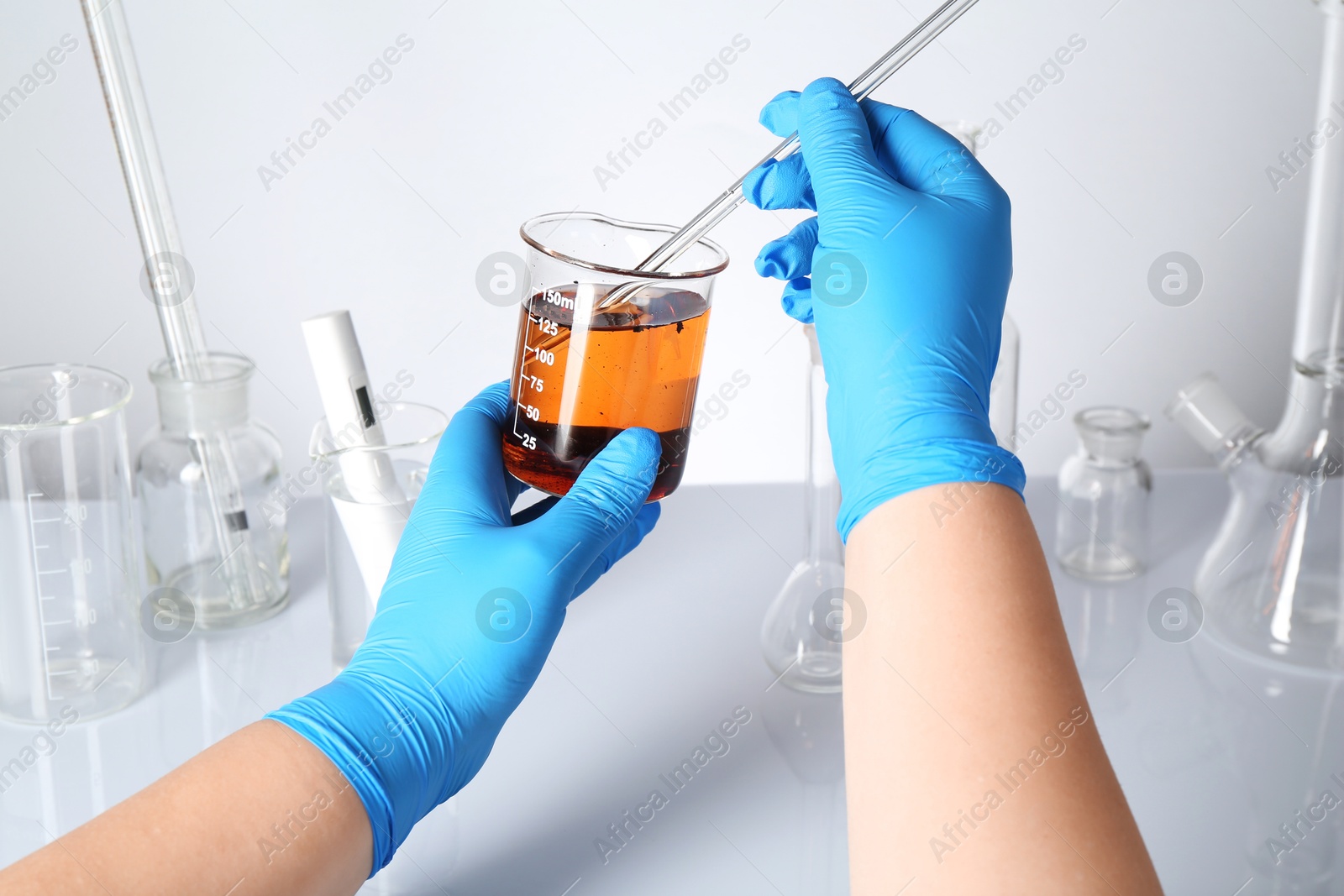 Scientist testing dirty water at white table, closeup Photo of Scientist testing dirty water at white table, closeup