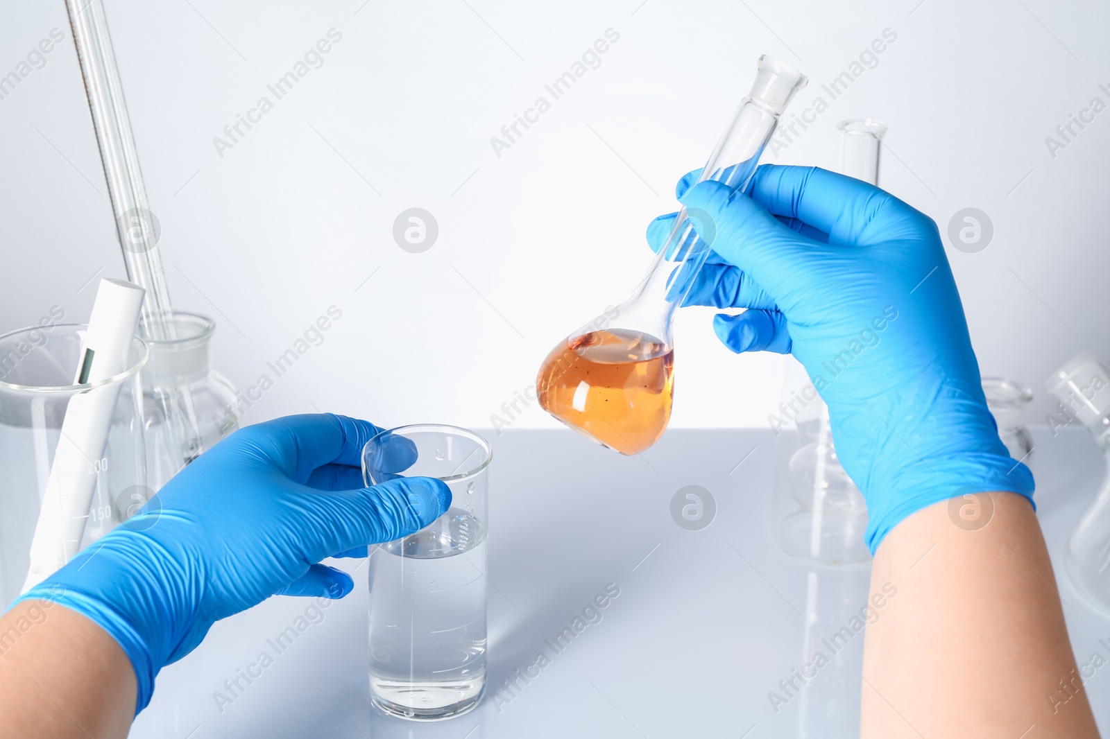 Scientist with clean and dirty water at white table, closeup Photo of Scientist with clean and dirty water at white table, closeup