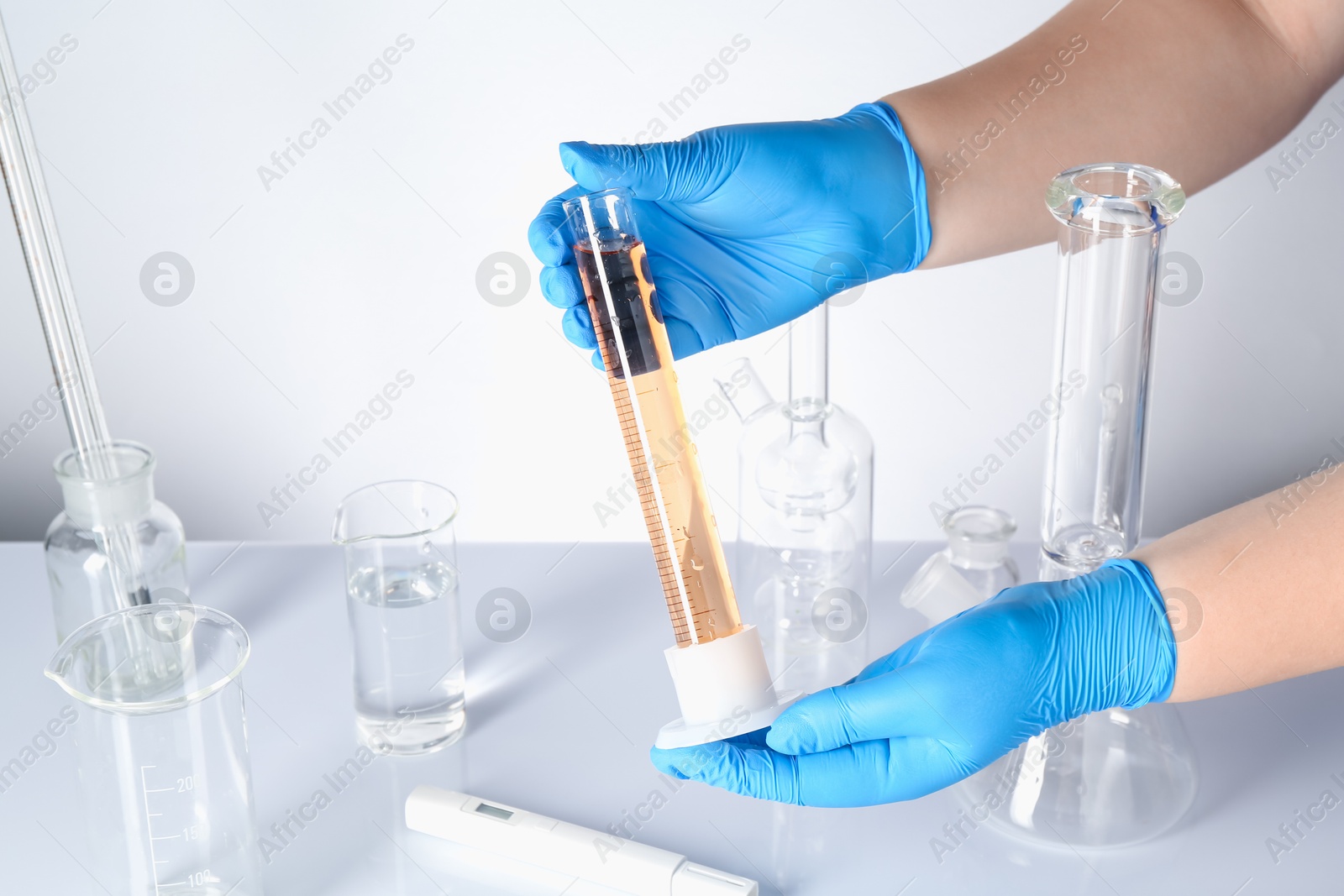 Scientist testing dirty water at white table, closeup Photo of Scientist testing dirty water at white table, closeup