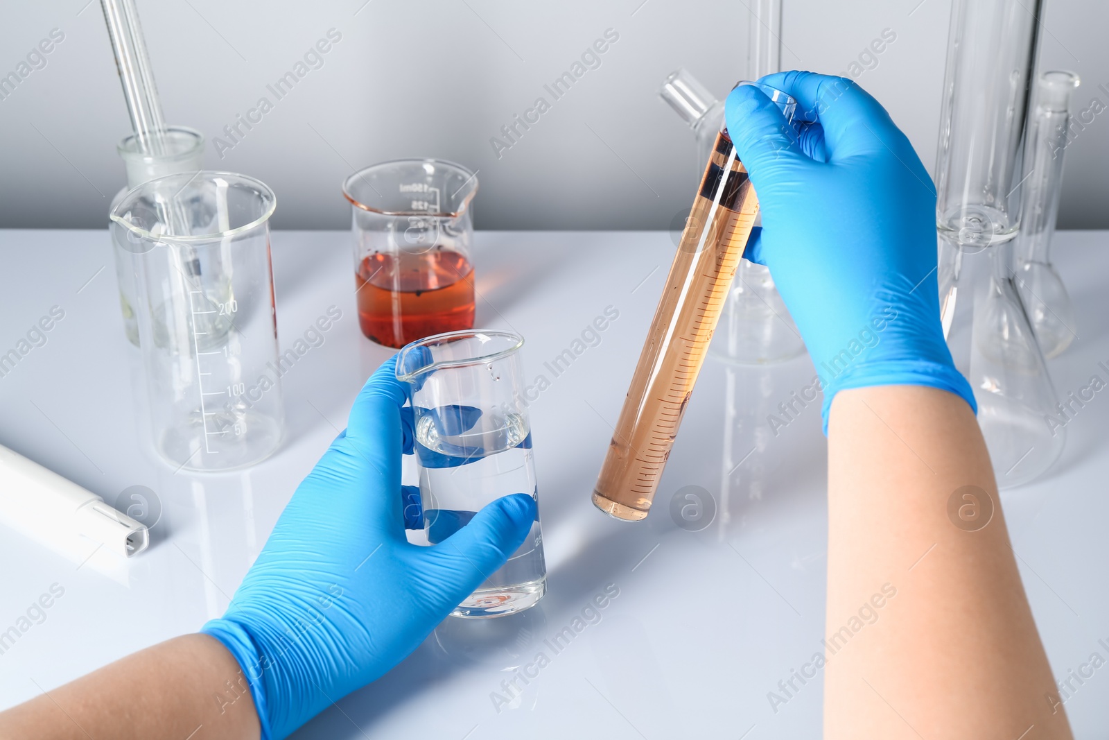 Scientist with clean and dirty water at white table, closeup Photo of Scientist with clean and dirty water at white table, closeup