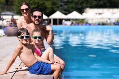 Photo of Happy family at poolside outdoors on sunny day, space for text
