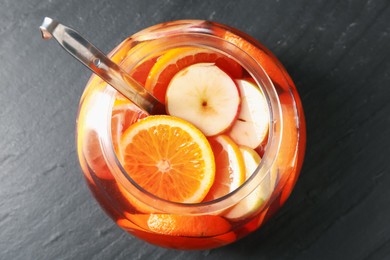 Photo of Fruity punch on black table, top view. Refreshing drink