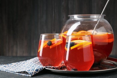 Photo of Fruity punch on black table, closeup. Space for text