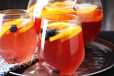 Photo of Fruity punch on black table, closeup. Refreshing drink