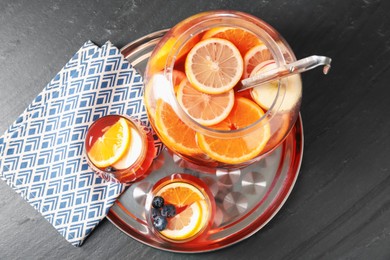 Photo of Fruity punch on black table, top view. Refreshing drink