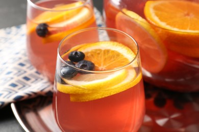 Photo of Fruity punch on black table, closeup. Refreshing drink