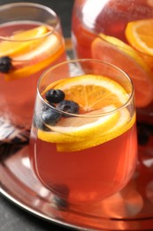Photo of Fruity punch on black table, closeup. Refreshing drink