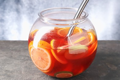 Photo of Fruity punch on grey table, closeup. Refreshing drink