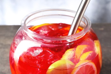 Photo of Fruity punch on grey table, closeup. Refreshing drink