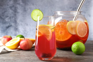 Photo of Punch and fresh fruits on grey table, closeup. Refreshing drink