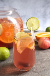 Photo of Punch and fresh fruits on grey table, closeup. Refreshing drink
