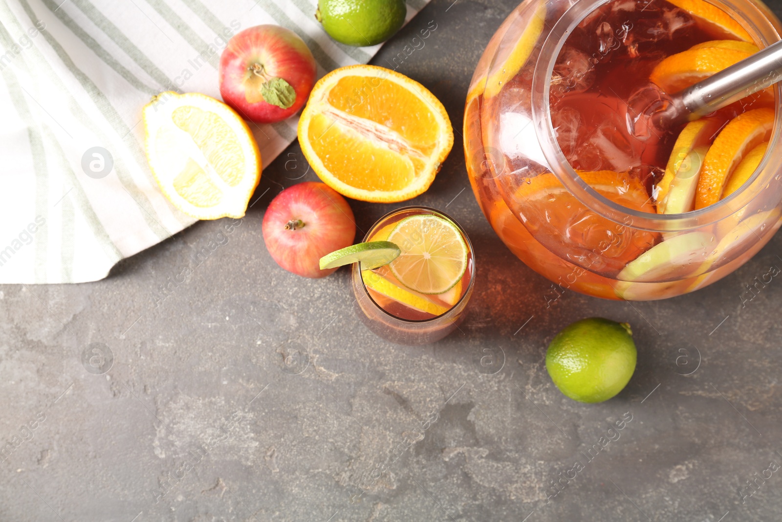 Punch and fresh fruits on grey table, flat lay with space for text. Refreshing drink Photo of Punch and fresh fruits on grey table, flat lay with space for text. Refreshing drink