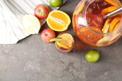 Photo of Punch and fresh fruits on grey table, flat lay with space for text. Refreshing drink
