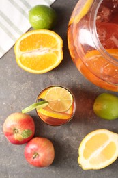 Photo of Punch and fresh fruits on grey table, flat lay. Refreshing drink